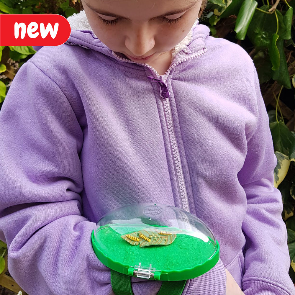 A child wearing the Catch a Bug Wrist Viewer, examining an insect up close. The viewer is equipped with a convenient wrist strap for easy use. Ideal for curious minds and nature enthusiasts interested in observing tiny insect details without causing harm